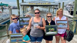 Captured moments of Assateague vacation joy: delighted customers proudly holding a trove of art prints from the Nature Photographer's gallery, featuring mesmerizing footage of wild horses, penguins, birds, and more.